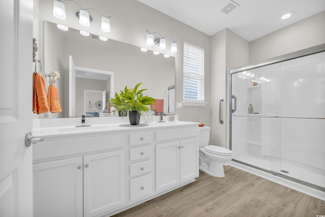 bathroom with vanity, toilet, hardwood / wood-style floors, and a shower with shower door