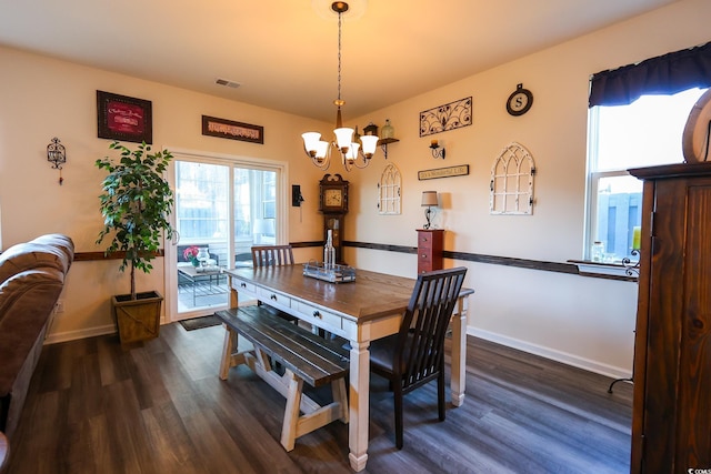 dining room featuring dark wood-type flooring and a chandelier