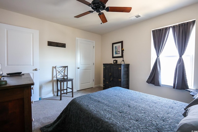 carpeted bedroom with ceiling fan and multiple windows