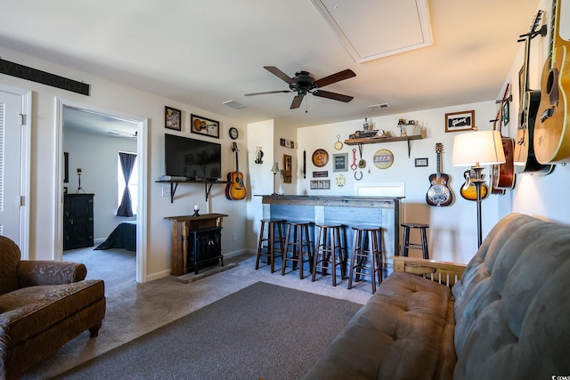 carpeted living room with ceiling fan and indoor bar