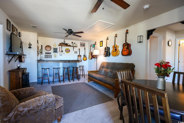 living room featuring bar, ceiling fan, and carpet flooring