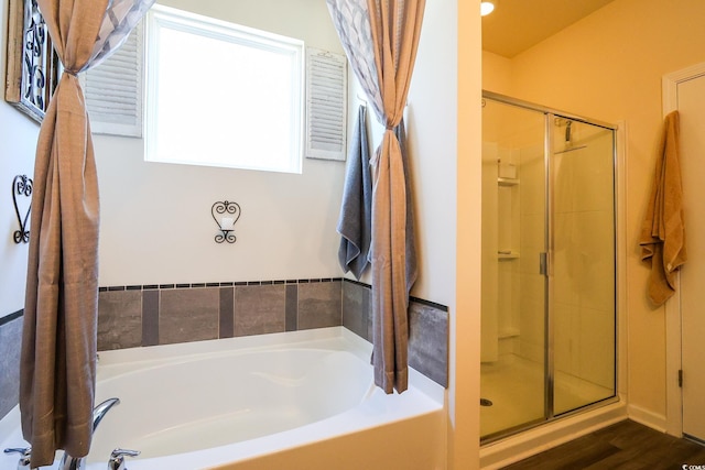 bathroom with hardwood / wood-style flooring and separate shower and tub