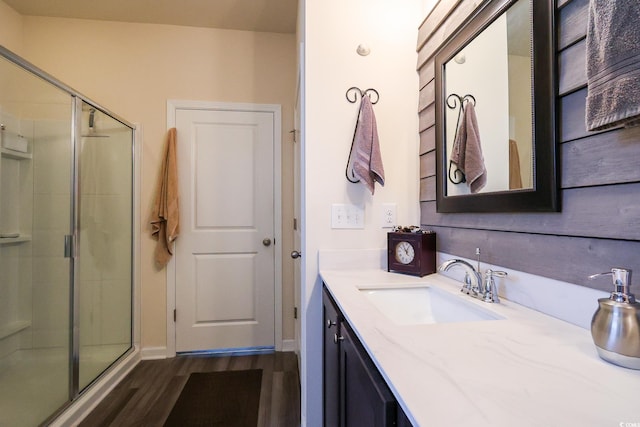 bathroom with vanity, a shower with shower door, and wood-type flooring