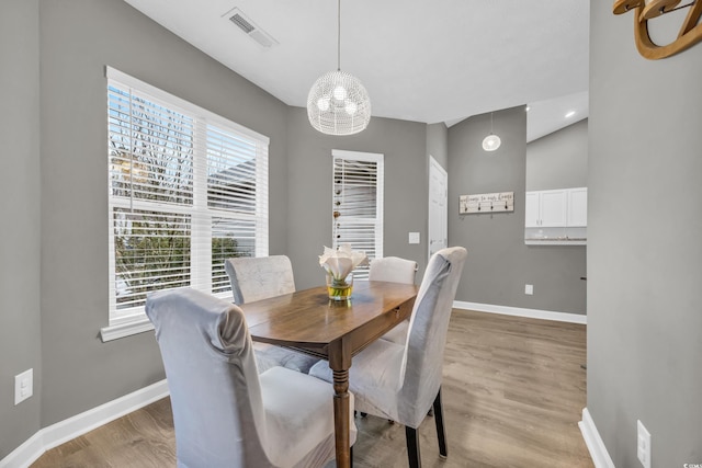 dining room featuring hardwood / wood-style flooring and lofted ceiling