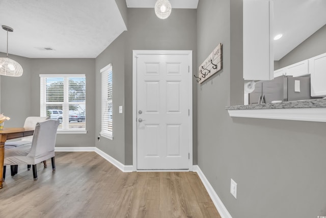 entrance foyer with light wood-style floors and baseboards