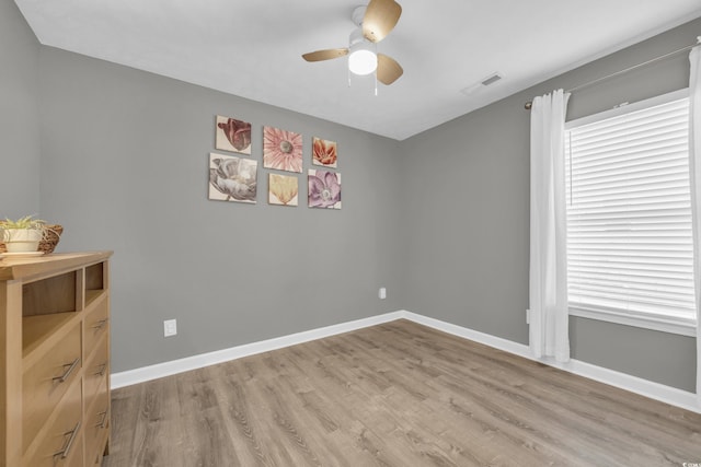 empty room featuring a ceiling fan, wood finished floors, and baseboards