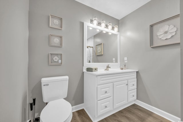 bathroom with wood-type flooring, toilet, and vanity