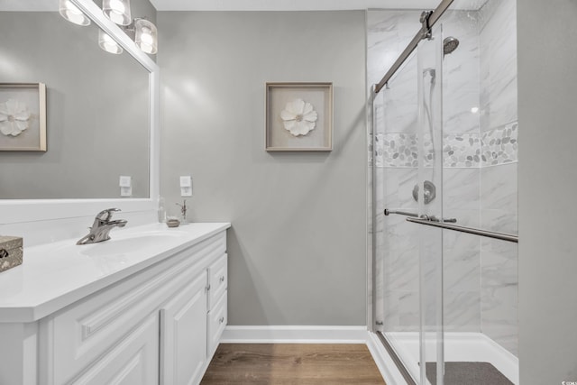 bathroom with an enclosed shower, vanity, and wood-type flooring