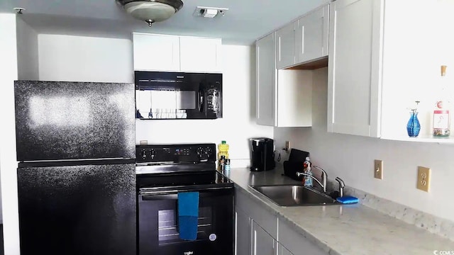 1605 S Ocean Blvd Unit 1602, Myrtle Beach, SC 29577 - kitchen with white cabinetry, sink, black appliances, and light stone countertops