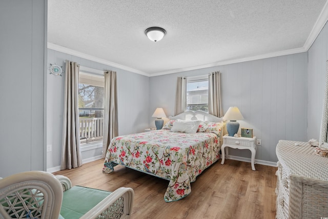 bedroom featuring hardwood / wood-style flooring, a textured ceiling, and ornamental molding