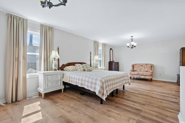 bedroom featuring light wood-type flooring and a chandelier