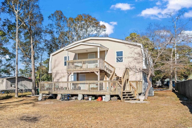 rear view of property featuring a lawn and a deck