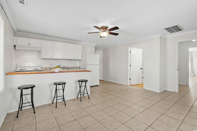 kitchen featuring white appliances, crown molding, white cabinets, kitchen peninsula, and a breakfast bar