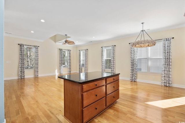 kitchen with pendant lighting, ceiling fan, crown molding, and light hardwood / wood-style floors