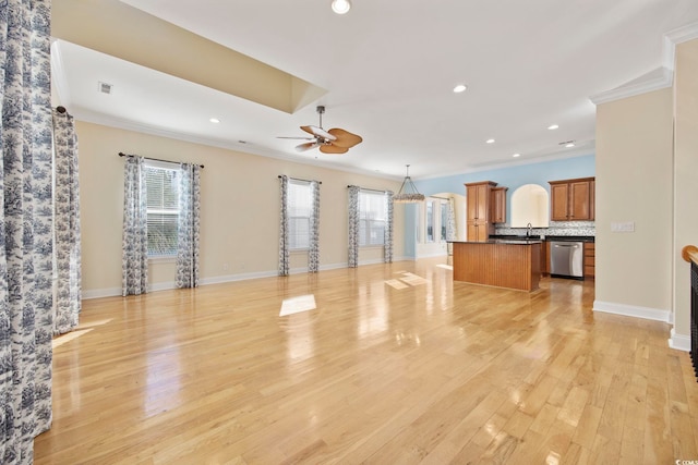 unfurnished living room featuring crown molding, plenty of natural light, and light hardwood / wood-style flooring