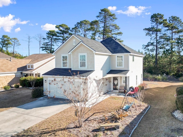 traditional-style house featuring a shingled roof, driveway, and an attached garage