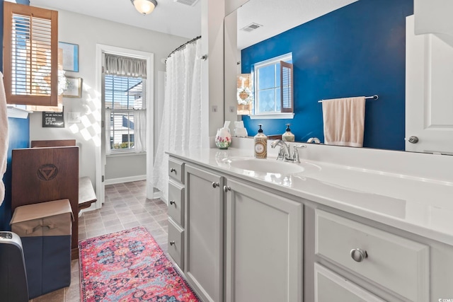 bathroom featuring tile patterned flooring, visible vents, vanity, and baseboards