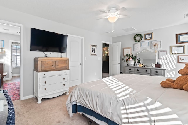 bedroom with light carpet, ceiling fan, visible vents, and baseboards