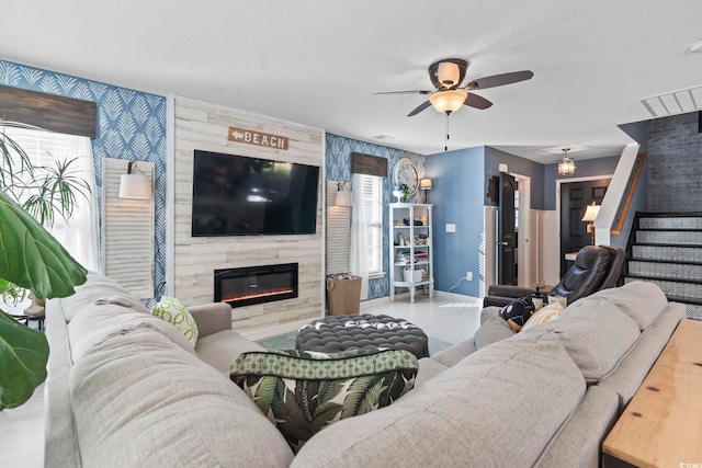 living room with baseboards, ceiling fan, stairway, a textured ceiling, and a high end fireplace