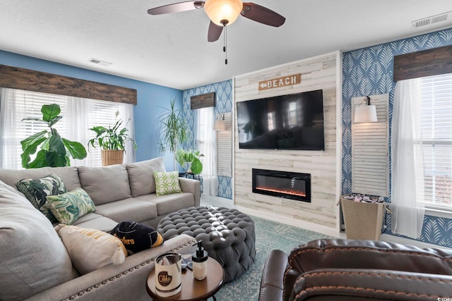 living area featuring plenty of natural light, a premium fireplace, and visible vents