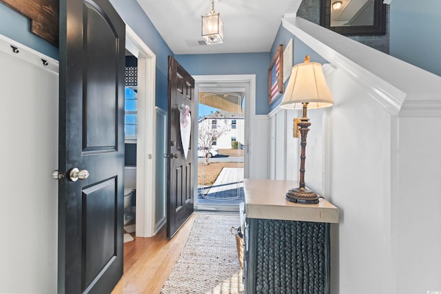 doorway featuring light wood-style flooring and visible vents