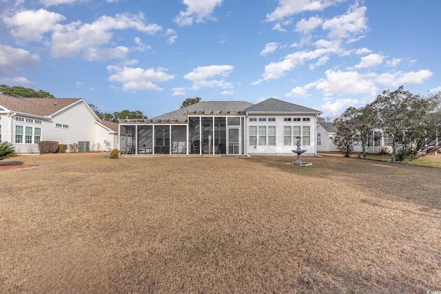 back of house featuring central AC unit, a sunroom, and a yard