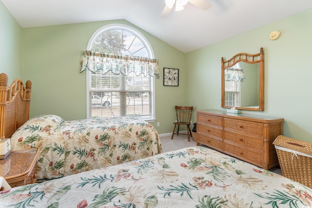 carpeted bedroom with ceiling fan and vaulted ceiling