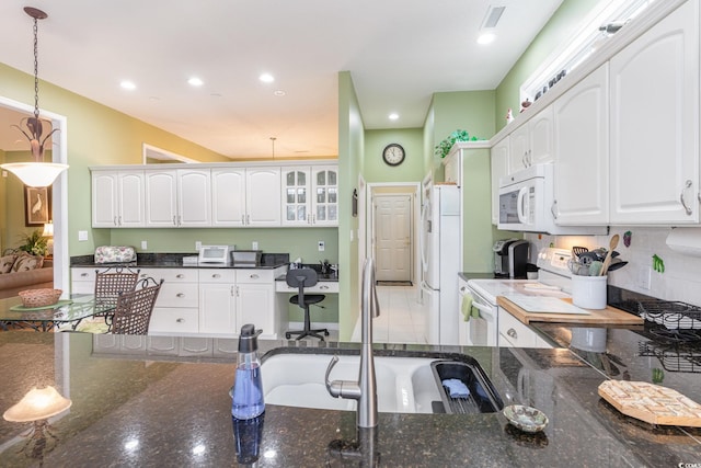 kitchen featuring white cabinets, built in desk, hanging light fixtures, and white appliances