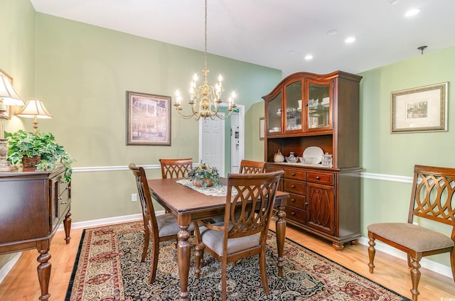 dining room featuring light hardwood / wood-style flooring and an inviting chandelier