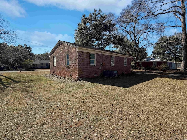 view of side of home with cooling unit and a yard