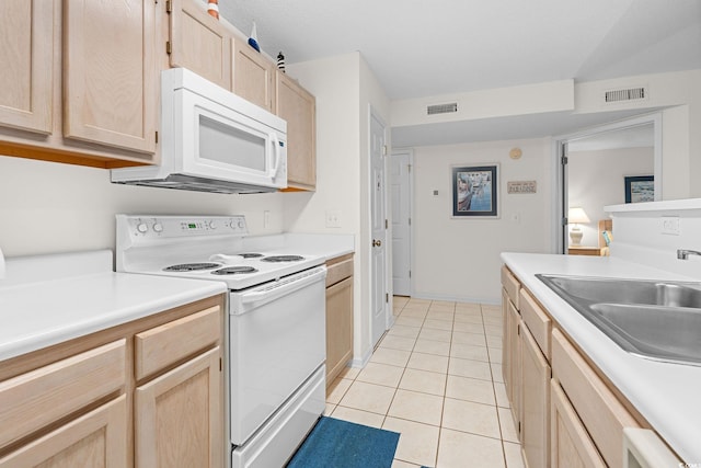 kitchen with sink, light tile patterned floors, light brown cabinetry, and white appliances