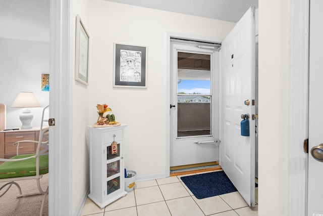 doorway with light tile patterned floors and a textured ceiling