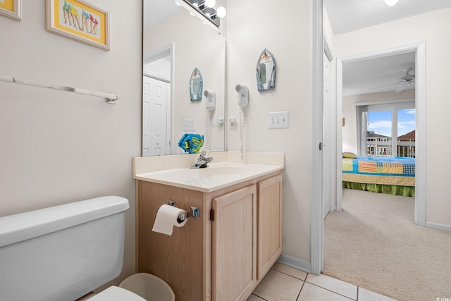 bathroom with vanity, ceiling fan, toilet, tile patterned floors, and a textured ceiling