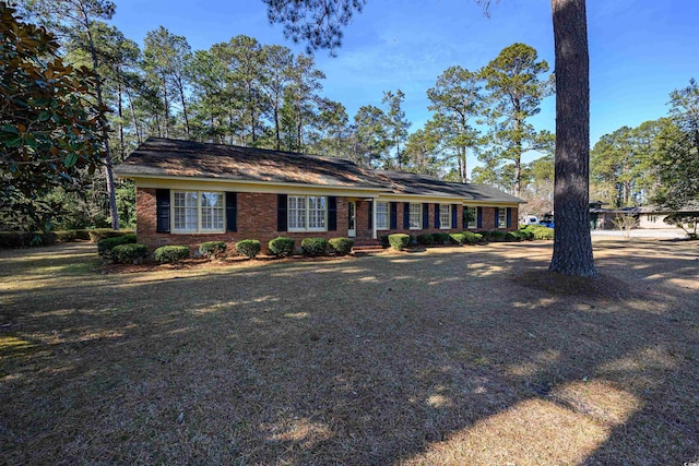 view of front facade featuring brick siding and a front yard