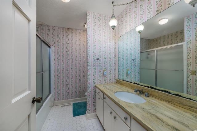 bathroom featuring visible vents, wallpapered walls, shower / bath combination with glass door, tile patterned floors, and vanity