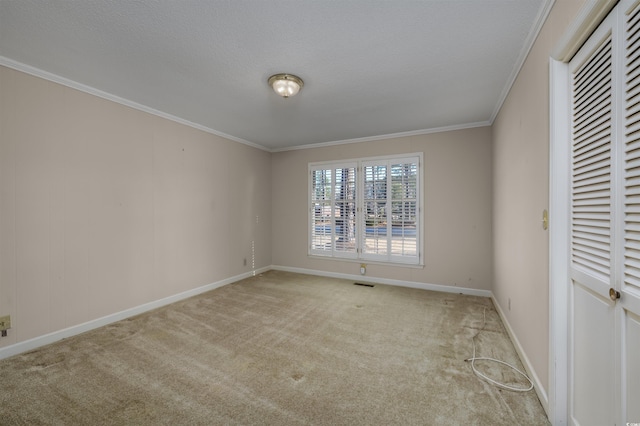 unfurnished bedroom featuring visible vents, baseboards, ornamental molding, carpet floors, and a textured ceiling