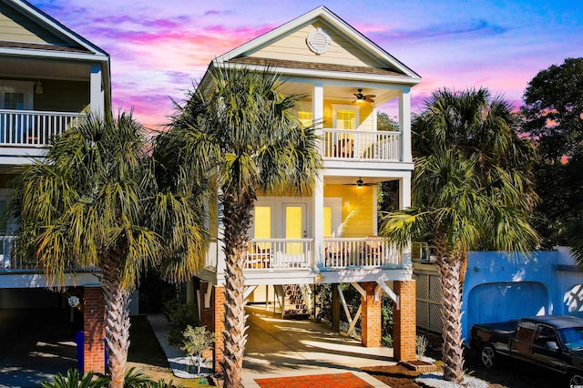 beach home featuring ceiling fan, covered porch, a balcony, and a carport