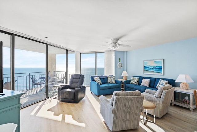 living room with light hardwood / wood-style floors, expansive windows, and ceiling fan