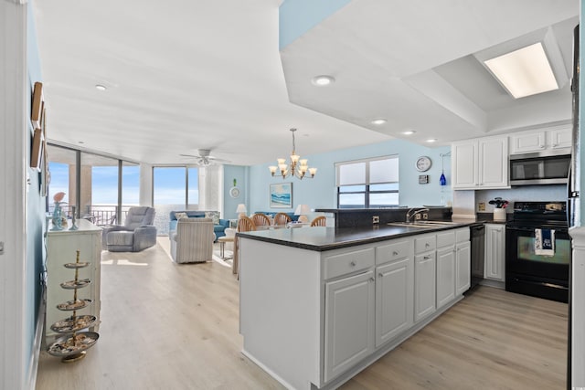 kitchen featuring black appliances, white cabinets, light hardwood / wood-style floors, kitchen peninsula, and floor to ceiling windows