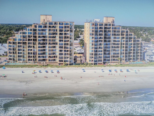 view of building exterior featuring a view of the beach and a water view