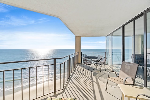 balcony featuring a water view and a beach view