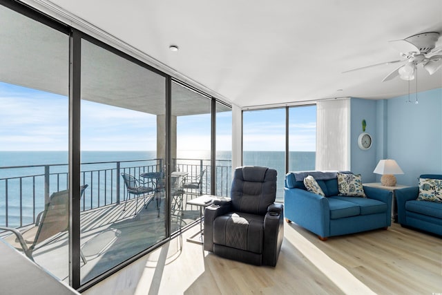 living room with a water view, expansive windows, and light hardwood / wood-style floors