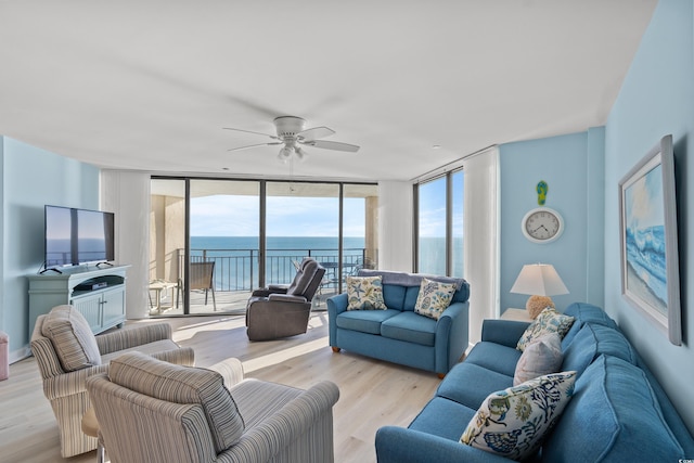 living room featuring expansive windows, ceiling fan, and light hardwood / wood-style floors