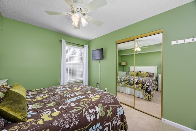 carpeted bedroom with a textured ceiling, a closet, and ceiling fan