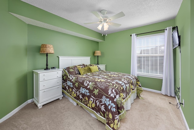 bedroom featuring ceiling fan, light colored carpet, and a textured ceiling