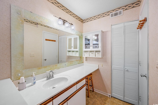 bathroom featuring tile patterned floors, a textured ceiling, and vanity