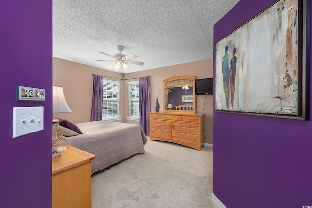 bedroom featuring ceiling fan, light colored carpet, and a textured ceiling