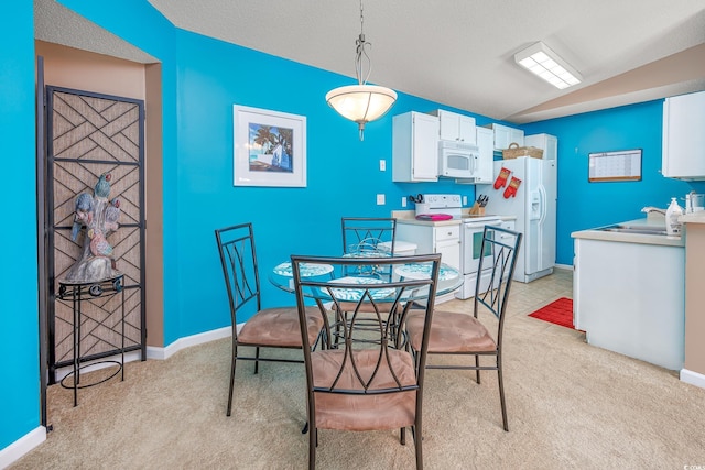 dining space featuring lofted ceiling, sink, and a textured ceiling