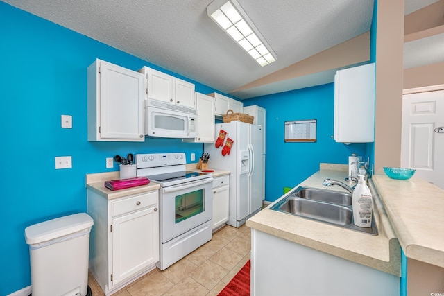 kitchen featuring light tile patterned floors, white appliances, vaulted ceiling, and white cabinets