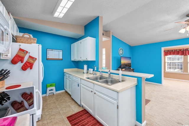 kitchen with vaulted ceiling, sink, white cabinets, light tile patterned floors, and white appliances